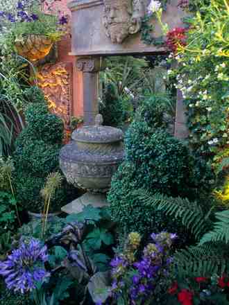 Spiral topiary box flanking the temple ruin folly in the Italianate garden.