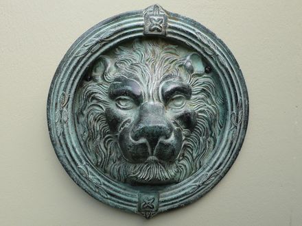 The bronze lions mask medallion on the Roman door in the garden.